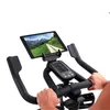 Close-up of a person's hands on the handlebars of an indoor cycling bike, with a tablet mounted above the console. Voir les images du produit