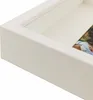 A close-up view of a white shadow box frame, showing a portion of a photograph inside. Produktbild-Vorschau