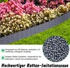 A garden border made of gray rattan-look plastic is shown in front of a flower bed with pink and white flowers and green grass. A pile of gray plastic pellets is in the lower right corner. Náhled obrázku produktu