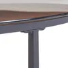 A close-up view of the edge of a round table, showing the metal frame and the glass tabletop. Náhľad obrázku produktu