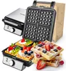 A waffle maker and waffles are displayed against a white background. The waffle maker is open, revealing the waffle grid. Several waffles, topped with fruit and whipped cream, are arranged in the foreground. Podgląd zdjęcia produktu