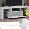 A white TV stand with a TV and media player on it. A yellow arrow points to a detail of the cabinet door. Produktbild-Vorschau