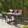 An outdoor dining set with chairs and a table is set up on a wooden deck, with a dense bamboo screen in the background. Produktbild-Vorschau