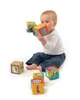 A baby sitting on the floor playing with soft foam blocks. Produktbild-Vorschau