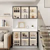 A modern living room with a display cabinet filled with decorative items and bottles, next to a sofa and a staircase. Produktbild-Vorschau