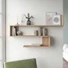 A modern living room with a wooden wall shelf displaying decorative items and books. Produktbild-Vorschau
