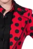 A close-up of a woman wearing a red and black polka dot jacket with a ladybug brooch. Produktbild-Vorschau