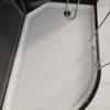 A close-up view of the interior of a modern shower tray with a drain. Anteprima dell’immagine prodotto