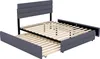 A gray upholstered bed frame with a slatted wooden support system and a pull-out trundle bed is shown against a white background. Produktbild-Vorschau