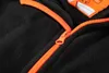 A close-up view of a black fleece sweatshirt with an orange zipper and trim. Podgląd zdjęcia produktu