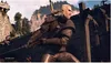 A character from The Witcher 3: Wild Hunt is depicted in a dynamic combat pose, holding a sword. The background shows a rugged, mountainous terrain with some wooden structures and a stone tower. Podgląd zdjęcia produktu