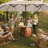 A group of people enjoying an outdoor gathering under a large umbrella. Náhled obrázku produktu