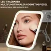 A woman applying makeup using an LED illuminated cosmetic mirror. Produktbild-Vorschau