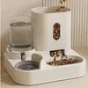 A white automatic pet feeder and water dispenser with kibble falling into the food bowl. Produktbild-Vorschau
