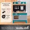 A wooden play kitchen with various accessories, set against a backdrop of wooden shutters and a brick wall. Produktbild-Vorschau
