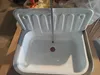 A white sink with a measuring tape placed vertically in the center. Náhled obrázku produktu