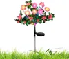 Rosa Blumen-Solar-Gartenleuchte mit grünen Blättern und einem schwarzen Solarpanel auf einem Pfahl, in grünem Gras Anteprima dell’immagine prodotto