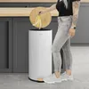 A person is throwing banana peels into a white trash can with a wooden lid and pedal. Podgląd zdjęcia produktu