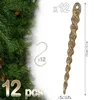 A close-up of glittery gold icicle ornaments and a Christmas tree branch. Anteprima dell’immagine prodotto