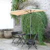 An outdoor patio scene with a table and chairs under a large umbrella. Anteprima dell’immagine prodotto
