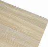 A close-up view of a light wood grain surface, likely a tabletop, with a rounded corner. Voir les images du produit