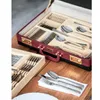 A close-up shot of a cutlery set in a burgundy case and a wooden box, placed on a wooden table. Voir les images du produit