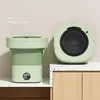 A light green, collapsible washing machine is shown in two views: one folded and one open, placed on a countertop. Náhled obrázku produktu