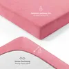 A close-up view of a pink fitted sheet, showing its texture and elastic edge. Produktbild-Vorschau