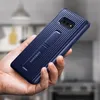 A hand holding a blue Samsung phone case with a kickstand. Produktbild-Vorschau