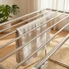 A close-up view of a metal drying rack with a towel draped over it. Produktbild-Vorschau