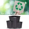 A hand holds a card with a recycling symbol against a blurred green background, with text below and three black plant pots. Produktbild-Vorschau