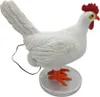 A white chicken figurine with a red comb and orange feet, sitting on a silver base. An egg is visible beneath its tail. Podgląd zdjęcia produktu