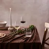 A table setting with wine glasses, a candle, and plates. Produktbild-Vorschau