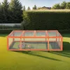 A wooden rabbit hutch with two rabbits inside, placed on a green lawn in a garden setting. Produktbild-Vorschau