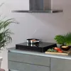 A kitchen counter with a portable induction cooktop cooking salmon, surrounded by fresh ingredients. Anteprima dell’immagine prodotto