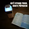 A power bank and an open book are placed on a wooden surface. Produktbild-Vorschau