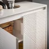 Close-up of a white bathroom vanity with textured cabinet doors and internal storage. Voir les images du produit