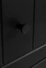 A close-up of a black cabinet knob on a black cabinet. Náhled obrázku produktu