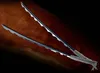 Two swords with serrated blades are laid diagonally on a wooden surface. Podgląd zdjęcia produktu