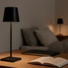 A bedside table with a lamp, book, and laptop. Produktbild-Vorschau