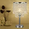 A crystal table lamp is displayed on a surface next to decorative items and a coffee cup. Podgląd zdjęcia produktu