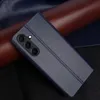 A dark blue flip cover phone case is shown diagonally on a dark background with brown and dark blue textured elements behind it. Produktbild-Vorschau