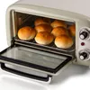 A close-up view of a retro-style toaster oven with several golden-brown bread rolls inside. Náhled obrázku produktu