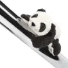 A plush panda toy is clinging to a shiny metallic pole. Produktbild-Vorschau