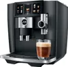 A black JURA coffee machine with a glass of coffee in front of it. Produktbild-Vorschau