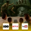 A family is watching a movie projected onto a screen, with streaming service logos at the bottom. Voir les images du produit