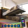 A bed with its storage compartment open, showing the interior and the lifting mechanism. The headboard has LED lighting. Voir les images du produit