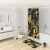 A modern bathroom with a shower curtain, toilet, sink, and bath mat, all featuring a golden leaf pattern. Produktbild-Vorschau