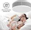 A family sleeping peacefully in bed, with a smoke detector shown above. Produktbild-Vorschau