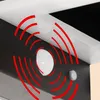 A close-up view of two outdoor solar-powered motion sensor lights, with red wavy lines indicating motion detection. Produktbild-Vorschau